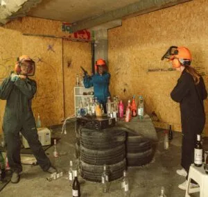 Woman raising a hammer triumphantly in a rage room